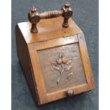 A vintage oak coal scuttle with carved front.