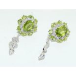 Pair of silver CZ and Peridot snake form drop earrings.