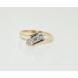 18ct yellow gold three stone Diamond cross over ring - 60 points approx. Size M.