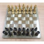 A modern marble chess board with full set of playing pieces.