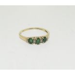 An Emerald and diamond trilogy ring in 9ct gold size O.