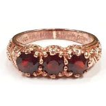 A Rose gold 9ct garnet three stone ring, size M