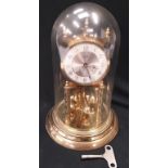 Glass domed Kundo celebration clock, approx 30cm high, with key.