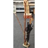 A vintage brass umbrella/stick stand together with a collection of sticks.