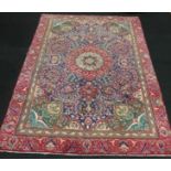Handmade woollen Tabriz carpet with central medallions in red and blue guard with repeated rosette