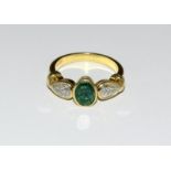 An 18ct gold and Emerald ring approx. 1.00ct with two side diamonds, approx. 0.40 points.