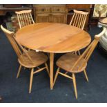 An Ercol golden blonde drop leaf kitchen table with four Goldsmith chairs.
