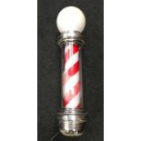 An illuminated vintage barbers pole.