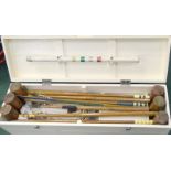 A vintage croquet set in it's fitted box complete with mallets bowls measuring instruments