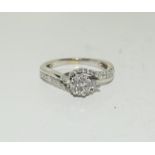 A Diamond cluster twist and diamond shoulder ring on white gold size L.