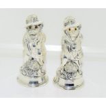 A pair of silver plated condiments in the form of dogs with hats.