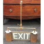 A vintage brass illuminated "EXIT" sign.