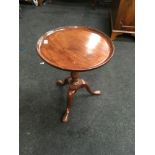 Round mahogany wine table on tripod supports.