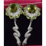 A pair of silver CZ and Peridot snake style earrings.