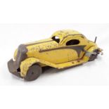 A yellow tinplate wind up model car with key - 33cm long.