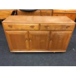 An Ercol style golden honey blonde two drawer over three door sideboard.