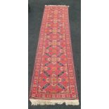 Antique carpet runner on red ground.