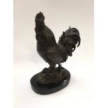 A bronzed figure of a cockerel on marble base.