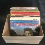 ELVIS PRESLEY VINYL RECORDS. A box containing E.P's and 7" singles from the 60's and 70's all in