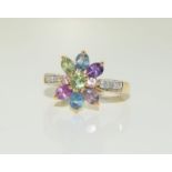 A 9ct gold diamond and semi precious set ring, Size N.