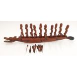 Heavily carved African dragon boat with carved men.