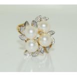 A 9ct gold ladies diamond and pearly cluster ring, Size N.