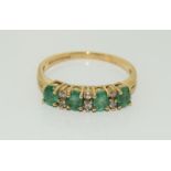 A 9ct gold ladies diamond and emerald ring, Size O.