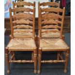Set of four ladder back dining chairs with wicker seat pads.