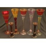 A collection of five coloured patterned stemmed glasses together with a pair of smaller coloured