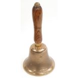 A vintage brass school bell with wooden handle.