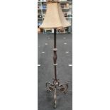 A decorative wrought iron black standard lamp complete with shade.
