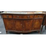 A mahogany serpentine fronted sideboard with three drawers over three cupboards and glass top.