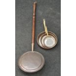 A bed warming pan and a set of copper frying pans.