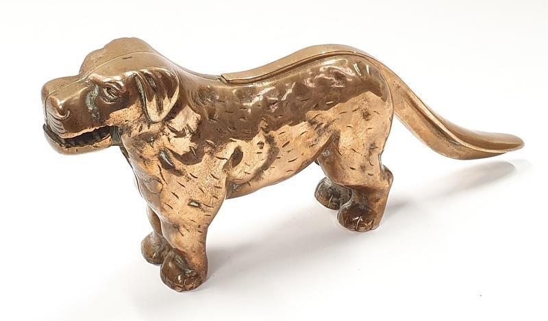 A solid brass anrique nut cracker in the form of a dog.