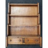 A vintage oak wall hanging spice rack with drawers.