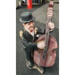 A model of Oliver Hardy holding a double bass.