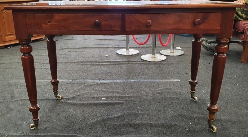 Victorian mahogany two drawer writing desk on turned supports with porcelain castors.