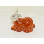 A silver and amber style rabbit figure.