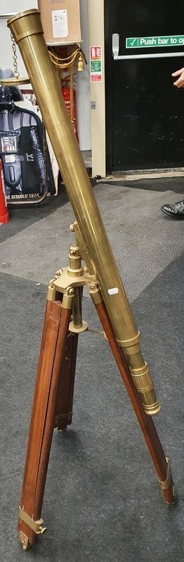 A brass telescope on tripod base.