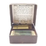 A vintage miniature microscope with glass slides in original box.