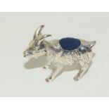 A silver goat pin cushion.