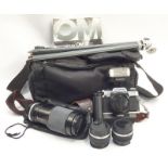 Vintage Olympus OM-20 35mm camera together with a collection of lenses and accessories.