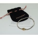 A Pandora silver bangle with 14ct gold clasp in bag.