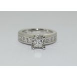 A 14ct white gold and diamond ring with central princess cut diamond. Size K
