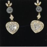 A pair of yellow gold south sea pearl and diamond heart shaped earrings.
