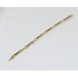 An 18ct yellow gold emerald and diamond line bracelet of 2.6cts approx.