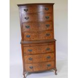 A 1930s burr figured walnut bowfronted chest on chest, with oak lined drawers and hand cut