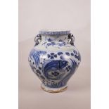 A Chinese blue and white Ming style pottery vase with two dragon handles, decorated with carp in a