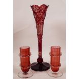 A Bohemian red overlay and etched glass trumpet vase, 10½" high, together with a pair of cranberry
