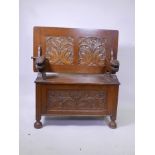 An oak monk's bench with carved decoration, raised on turned supports, early C20th, 36" x 19" x 27"